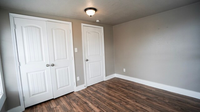 1126 Ryon St, Houston, TX 77009 - unfurnished bedroom with dark wood-style floors, baseboards, and a closet