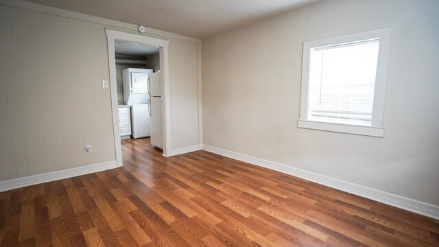 1126 Ryon St, Houston, TX 77009 - unfurnished room featuring stacked washer / dryer, wood finished floors, and baseboards