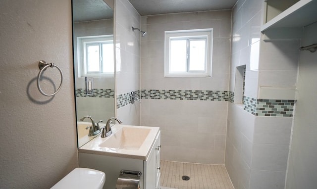 1126 Ryon St, Houston, TX 77009 - bathroom with a tile shower, toilet, plenty of natural light, vanity, and a textured wall