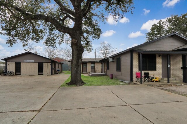 1916 Holloman Dr, Port Lavaca, TX 77979 - view of front of home featuring brick siding, a wall unit AC, driveway, entry steps, and a front yard
