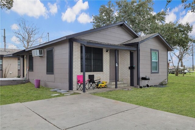 1916 Holloman Dr, Port Lavaca, TX 77979 - ranch-style home with a front lawn, an AC wall unit, and brick siding