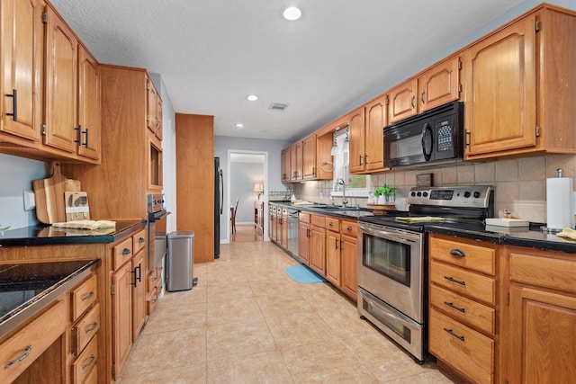 11723 Quail Creek Dr, Houston, TX 77070 - kitchen with stainless steel appliances, dark countertops, decorative backsplash, a sink, and recessed lighting