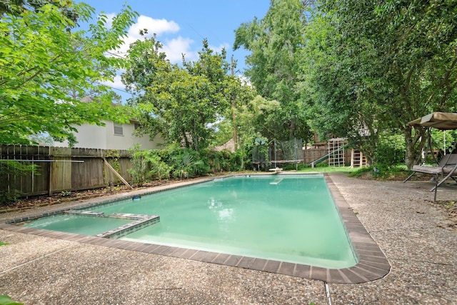 11723 Quail Creek Dr, Houston, TX 77070 - view of pool with a fenced backyard, a pool with connected hot tub, a trampoline, and a diving board