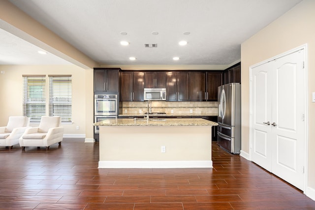 4911 Lattimore Creek Dr, Houston, TX 77084 - kitchen with appliances with stainless steel finishes, backsplash, dark brown cabinetry, dark wood-style floors, and recessed lighting