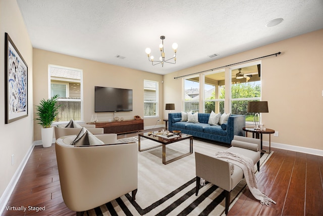 4911 Lattimore Creek Dr, Houston, TX 77084 - living room featuring baseboards, wood finished floors, a chandelier, a textured ceiling, and healthy amount of natural light