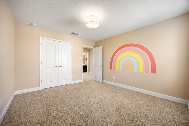 4911 Lattimore Creek Dr, Houston, TX 77084 - unfurnished bedroom featuring carpet, baseboards, a closet, and a textured ceiling