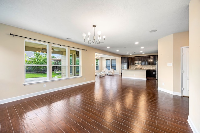 4911 Lattimore Creek Dr, Houston, TX 77084 - unfurnished living room featuring a chandelier, dark wood-style flooring, baseboards, and recessed lighting