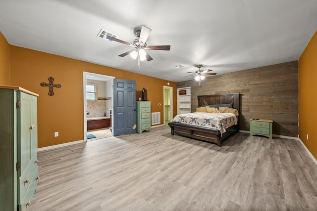 1307 Hillcrest Dr, Granite Shoals, TX 78654 - bedroom featuring light wood finished floors, baseboards, wood walls, connected bathroom, and a ceiling fan