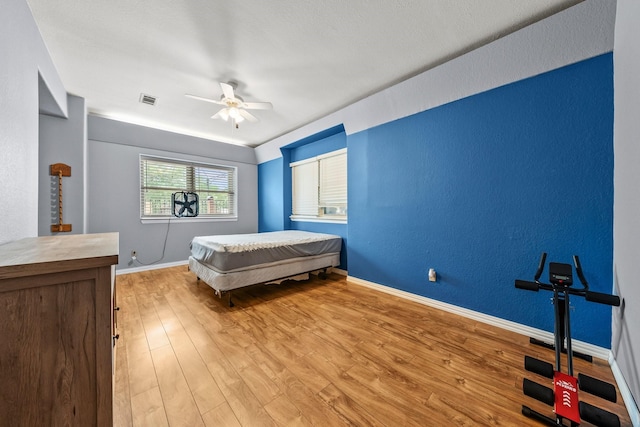 1307 Hillcrest Dr, Granite Shoals, TX 78654 - bedroom with wood finished floors, baseboards, ceiling fan, and a textured wall