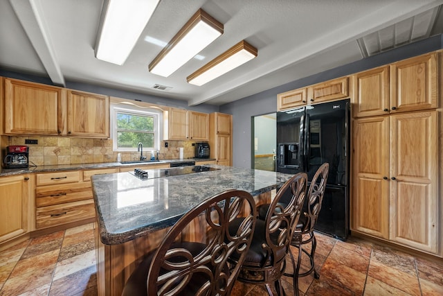 1307 Hillcrest Dr, Granite Shoals, TX 78654 - kitchen with black appliances, stone tile floors, a breakfast bar, backsplash, and dark stone countertops