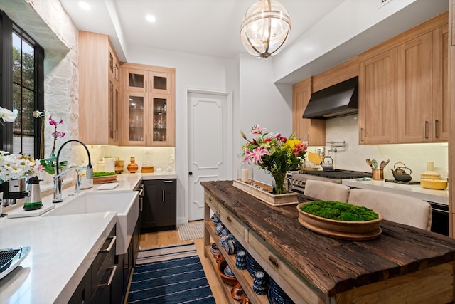 10 S Briar Hollow Ln Unit 30, Houston, TX 77027 - kitchen with wall chimney range hood, light brown cabinetry, light countertops, glass insert cabinets, and decorative backsplash