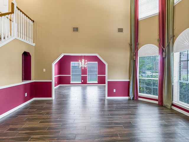 15510 Tysor Park Ln, Houston, TX 77095 - unfurnished living room featuring wood finished floors, a towering ceiling, baseboards, and a chandelier
