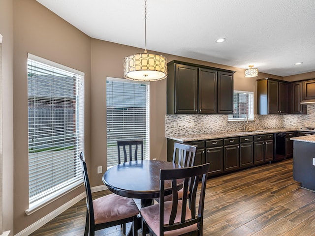 15510 Tysor Park Ln, Houston, TX 77095 - kitchen featuring dark wood-type flooring, decorative backsplash, dark brown cabinets, a sink, and light stone counters