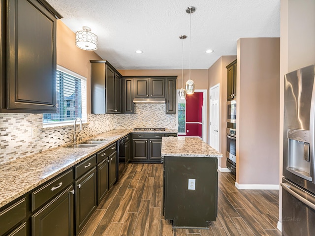 15510 Tysor Park Ln, Houston, TX 77095 - kitchen featuring appliances with stainless steel finishes, a sink, a center island, dark wood finished floors, and a textured ceiling