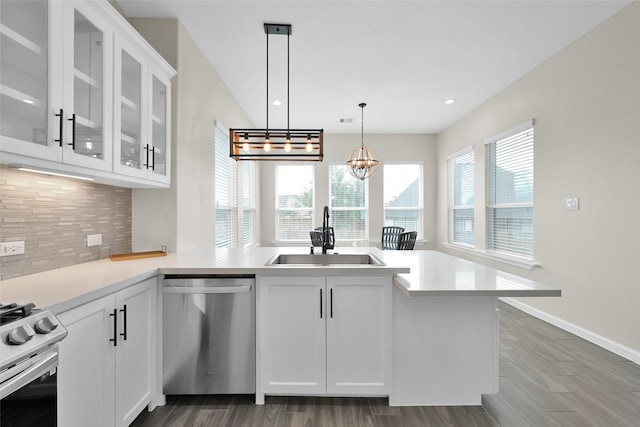 40380 Mostyn Dr, Magnolia, TX 77354 - kitchen with appliances with stainless steel finishes, a sink, tasteful backsplash, a peninsula, and white cabinets