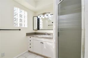 5502 Dumfries Dr, Houston, TX 77096 - full bath with a stall shower, tile patterned floors, baseboards, and vanity
