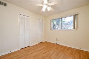 5502 Dumfries Dr, Houston, TX 77096 - unfurnished bedroom with wood finished floors, baseboards, two closets, and ceiling fan