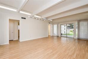 5502 Dumfries Dr, Houston, TX 77096 - empty room featuring beamed ceiling, wood finished floors, and baseboards