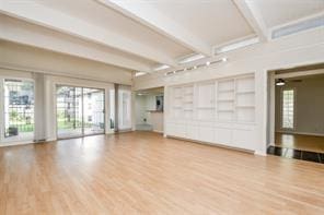 5502 Dumfries Dr, Houston, TX 77096 - unfurnished living room with beam ceiling, wood finished floors, and built in shelves