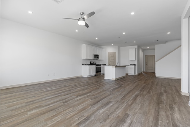 407 Emma St, Angleton, TX 77515 - unfurnished living room with wood finished floors, recessed lighting, a ceiling fan, baseboards, and a sink