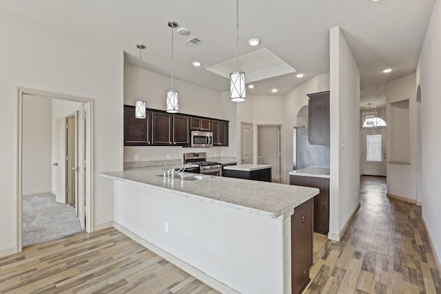 5207 Corbridge Glen Ct, Katy, TX 77449 - kitchen with stainless steel appliances, dark brown cabinets, light wood finished floors, light countertops, and plenty of natural light
