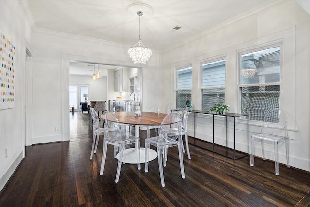 1130 Merrill St, Houston, TX 77009 - dining space with wood finished floors, a chandelier, ornamental molding, and baseboards
