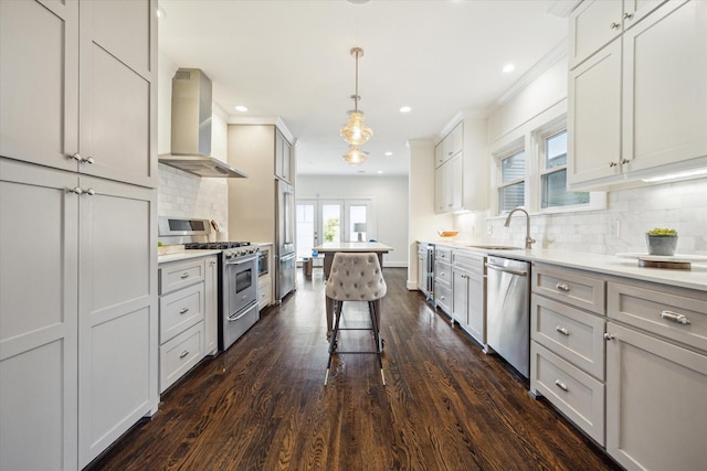 1130 Merrill St, Houston, TX 77009 - kitchen featuring appliances with stainless steel finishes, wall chimney range hood, a sink, dark wood finished floors, and tasteful backsplash