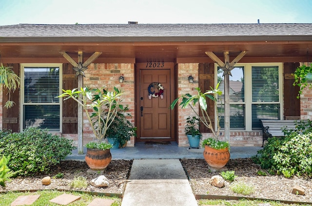 12023 Scottsdale Dr, Meadows Place, TX 77477 - entrance to property featuring roof with shingles, brick siding, and covered porch