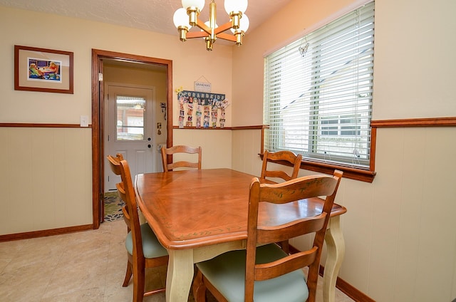 12023 Scottsdale Dr, Meadows Place, TX 77477 - dining area featuring a chandelier, healthy amount of natural light, a decorative wall, wainscoting, and baseboards