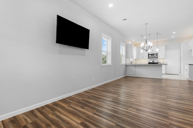 1505 Hussion St, Houston, TX 77003 - unfurnished living room with dark wood-type flooring, a chandelier, recessed lighting, and baseboards