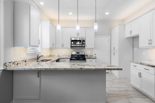 1505 Hussion St, Houston, TX 77003 - kitchen featuring appliances with stainless steel finishes, a sink, a peninsula, white cabinets, and recessed lighting