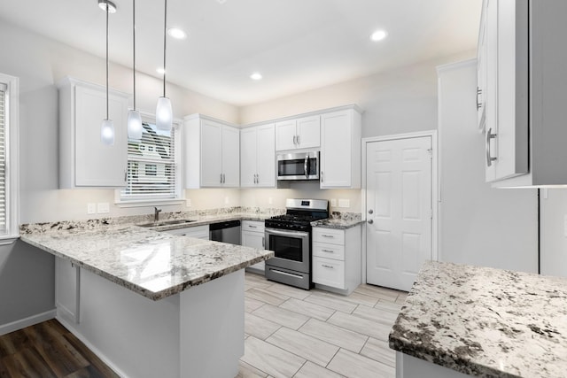 1505 Hussion St, Houston, TX 77003 - kitchen with stainless steel appliances, a sink, white cabinets, a peninsula, and recessed lighting