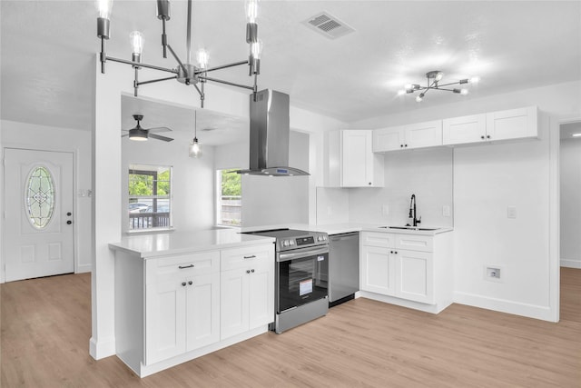 607 Rosedale St, La Marque, TX 77568 - kitchen featuring appliances with stainless steel finishes, wall chimney range hood, a sink, light wood-type flooring, and light countertops
