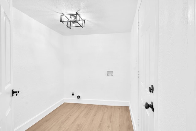 607 Rosedale St, La Marque, TX 77568 - laundry area featuring baseboards, light wood finished floors, hookup for a washing machine, a textured ceiling, and a chandelier