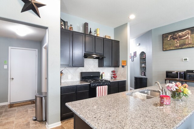 14726 Meadow Acre Trl, Houston, TX 77049 - kitchen featuring black gas range, a sink, under cabinet range hood, decorative backsplash, and stainless steel microwave
