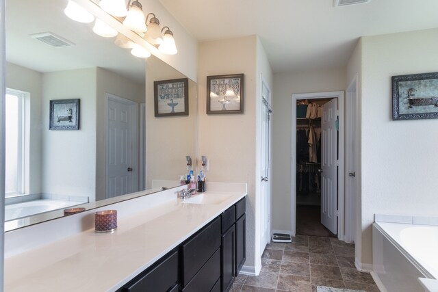 14726 Meadow Acre Trl, Houston, TX 77049 - bathroom featuring a garden tub, baseboards, vanity, a spacious closet, and stone finish floors