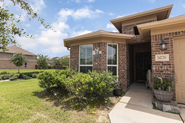 14726 Meadow Acre Trl, Houston, TX 77049 - doorway to property featuring brick siding and a yard