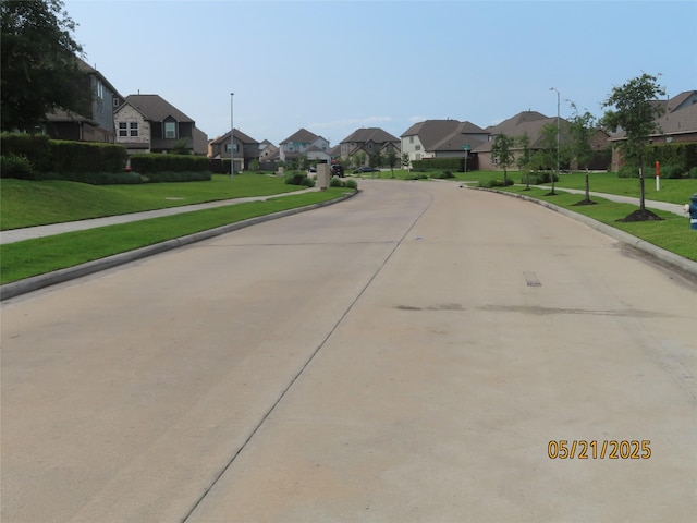 14726 Meadow Acre Trl, Houston, TX 77049 - view of concrete road featuring a residential view, curbs, street lights, and sidewalks