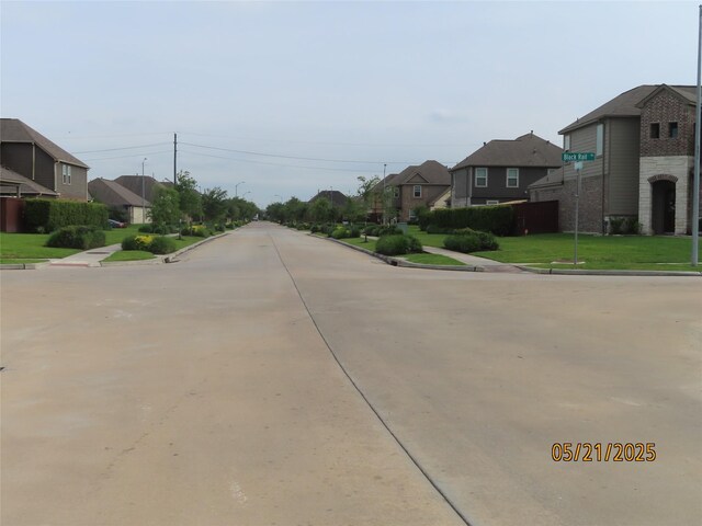 14726 Meadow Acre Trl, Houston, TX 77049 - view of concrete road with a residential view, curbs, and sidewalks