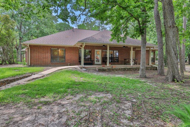 210 Harbor Run Dr, Coldspring, TX 77331 - rear view of house featuring ceiling fan, brick siding, roof with shingles, a lawn, and a patio