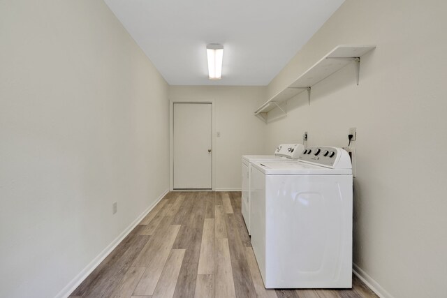 210 Harbor Run Dr, Coldspring, TX 77331 - laundry area with washer and clothes dryer, light wood finished floors, and baseboards