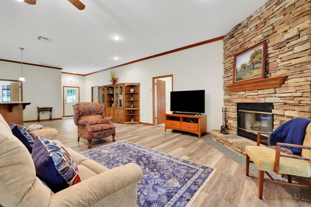 210 Harbor Run Dr, Coldspring, TX 77331 - living area with crown molding, light wood-style flooring, a stone fireplace, a ceiling fan, and baseboards