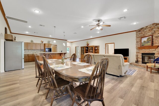 210 Harbor Run Dr, Coldspring, TX 77331 - dining space featuring light wood-type flooring, ornamental molding, a stone fireplace, recessed lighting, and a ceiling fan