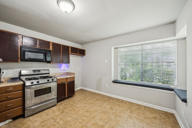 16211 Beck Ridge Dr, Houston, TX 77053 - kitchen with stainless steel gas range oven, black microwave, light countertops, and baseboards