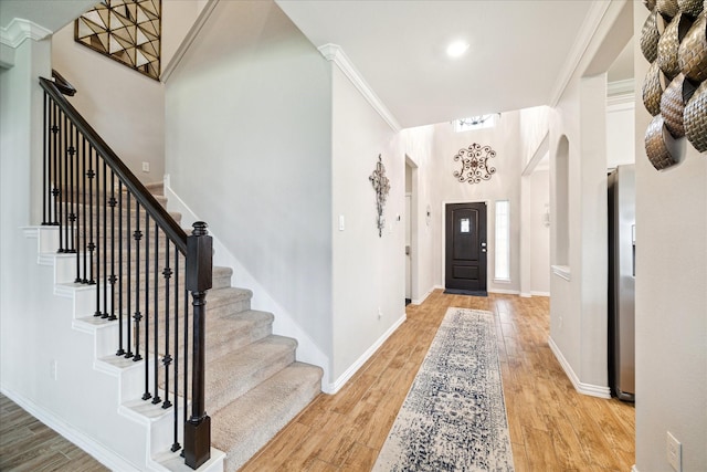 4423 Mimic Dr, Spring, TX 77386 - foyer entrance with light wood-style floors, stairs, baseboards, arched walkways, and a chandelier