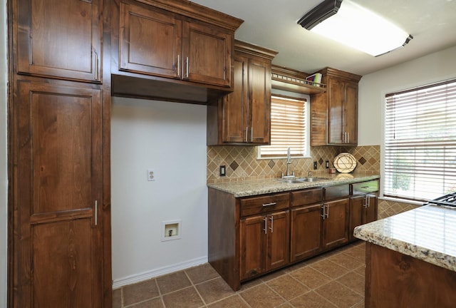 3000 Stevens Dr, Bryan, TX 77803 - kitchen with a sink, decorative backsplash, light stone countertops, and dark tile patterned flooring
