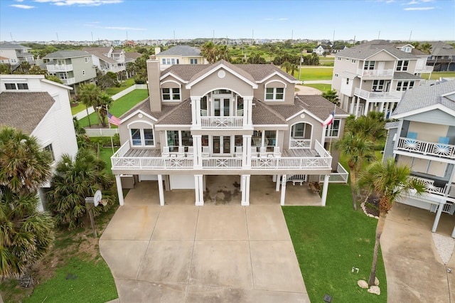 4100 Sand Crab Ln, Galveston, TX 77554 - rear view of property featuring a balcony, driveway, a shingled roof, a residential view, and a yard