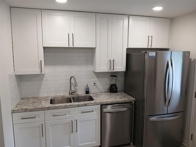 12907 Trail Hollow Dr Unit 2907, Houston, TX 77079 - kitchen with appliances with stainless steel finishes, a sink, white cabinetry, tasteful backsplash, and light stone countertops