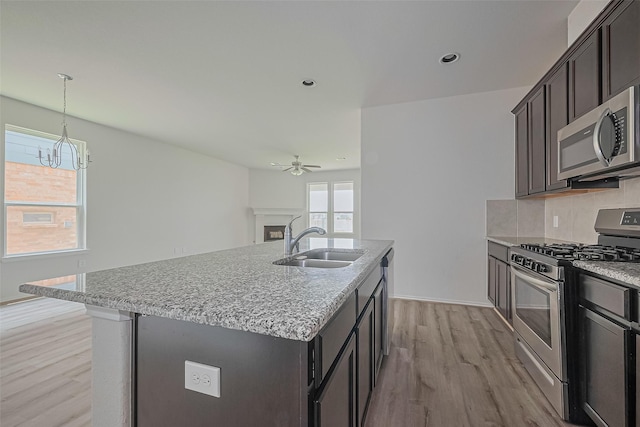 15502 Islandview Ln, Houston, TX 77053 - kitchen featuring stainless steel appliances, a sink, ceiling fan, light wood-type flooring, and a chandelier