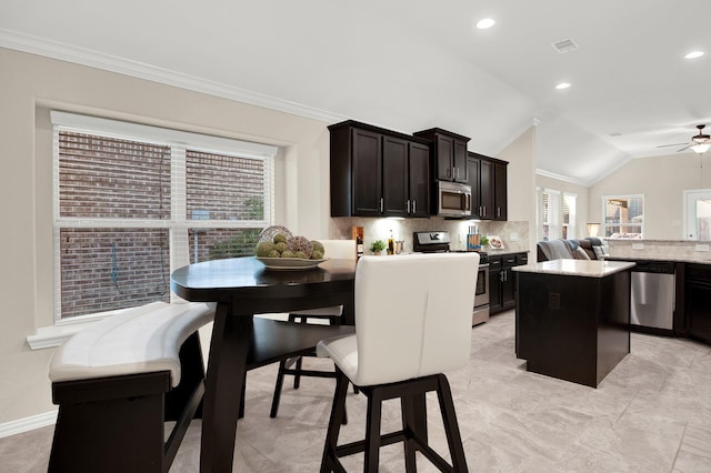 3864 Oakmist Bend Ln, Spring, TX 77386 - kitchen with stainless steel appliances, a center island, backsplash, a ceiling fan, and lofted ceiling